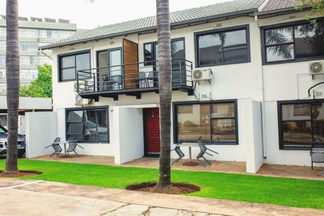 Two-storey Vetho 1 apartment block with balconies and a lawn