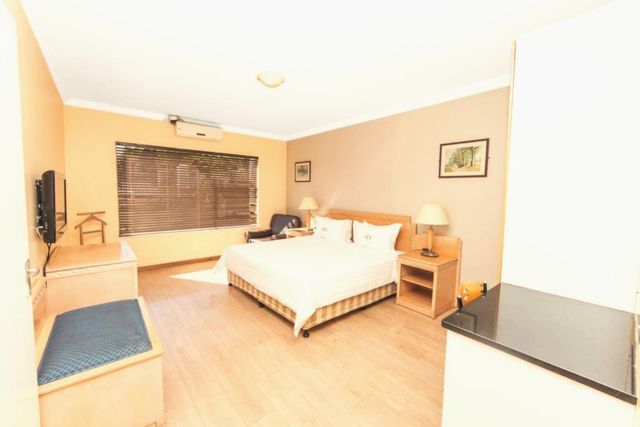 Bedroom with double bed, TV and wooden floors