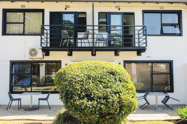 Apartment block with balconies behind a garden